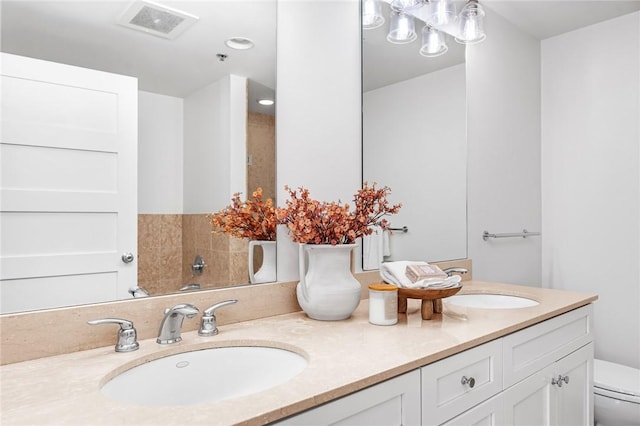 bathroom featuring toilet and double vanity