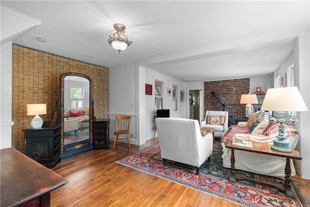 8001 Post Rd, North Kingstown, RI 02852 - living room with a wood stove, hardwood / wood-style floors, brick wall, and arched walkways