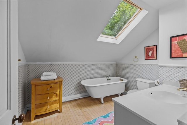 8001 Post Rd, North Kingstown, RI 02852 - bathroom featuring a skylight, lofted ceiling, hardwood / wood-style floors, wainscoting, and a freestanding bath