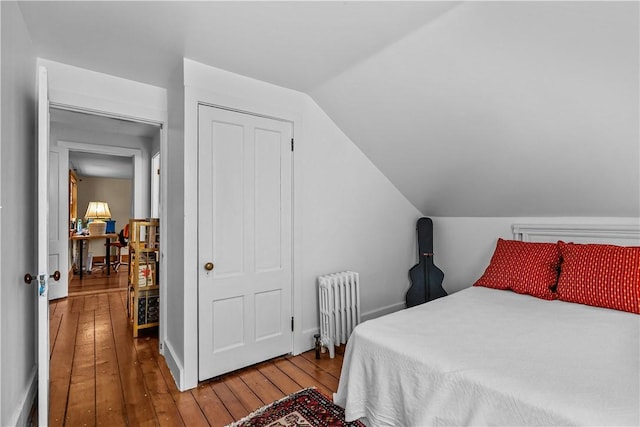 8001 Post Rd, North Kingstown, RI 02852 - bedroom featuring radiator heating unit, hardwood / wood-style floors, vaulted ceiling, and baseboards