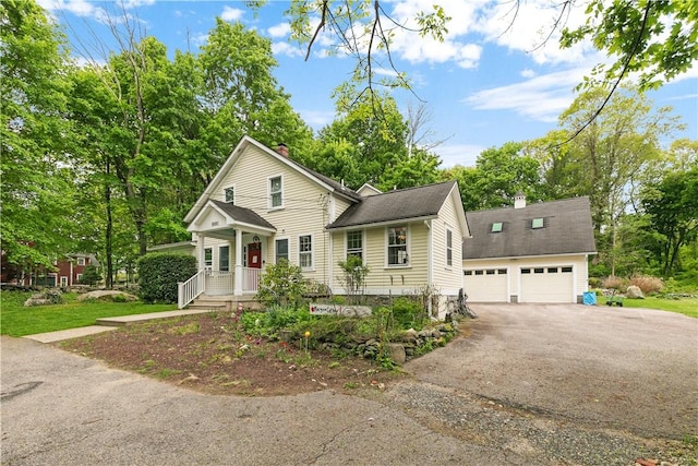 8001 Post Rd, North Kingstown, RI 02852 - traditional-style home with a chimney, a garage, asphalt driveway, and view of wooded area