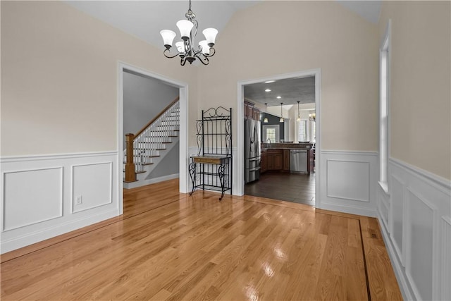 115 Read St, Attleboro, MA 02703 - unfurnished dining area with a chandelier, stairway, a decorative wall, wainscoting, and lofted ceiling