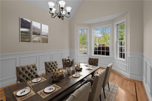 115 Read St, Attleboro, MA 02703 - dining area featuring a chandelier, a wainscoted wall, light wood-type flooring, a decorative wall, and lofted ceiling