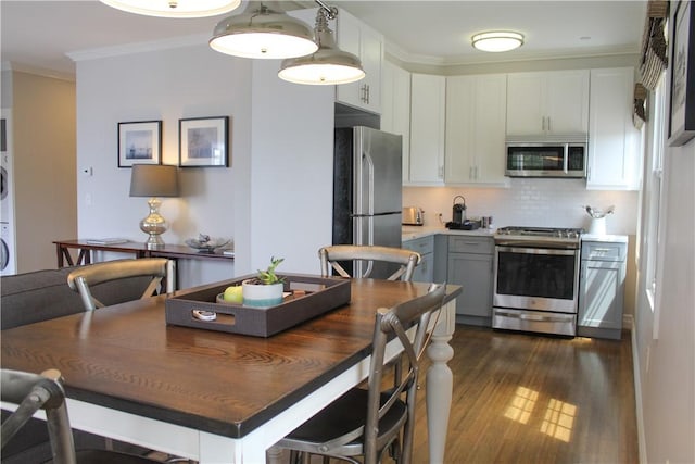 44 Bay St Unit B110, Westerly, RI 02891 - kitchen featuring stainless steel appliances, dark wood-style flooring, crown molding, backsplash, and white cabinets