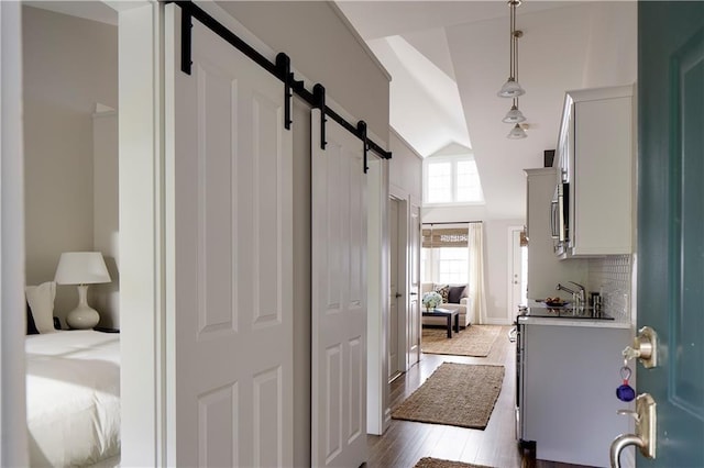 44 Bay St Unit B110, Westerly, RI 02891 - hallway with a barn door, dark wood-type flooring, and high vaulted ceiling