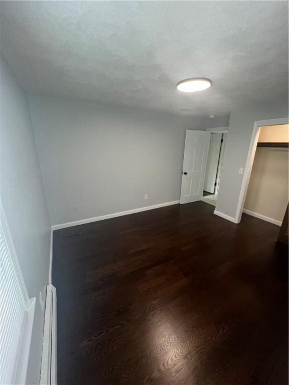 446 Angell Rd, North Providence, RI 02904 - empty room with baseboards, a baseboard heating unit, and dark wood finished floors