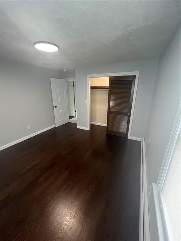 446 Angell Rd, North Providence, RI 02904 - unfurnished bedroom with baseboards, a closet, and dark wood-style flooring