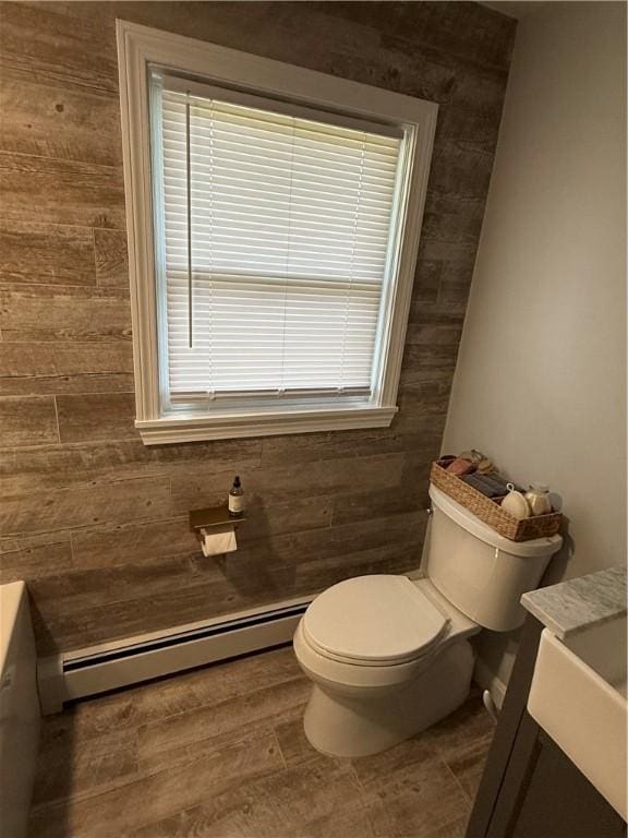 446 Angell Rd, North Providence, RI 02904 - half bath with a baseboard heating unit, vanity, toilet, and wooden walls