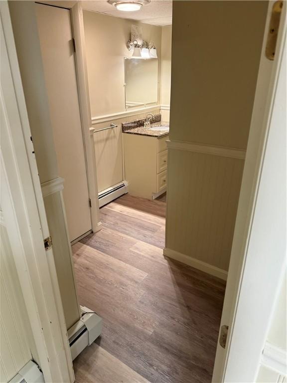 446 Angell Rd, North Providence, RI 02904 - bathroom with a baseboard radiator, wood finished floors, and vanity