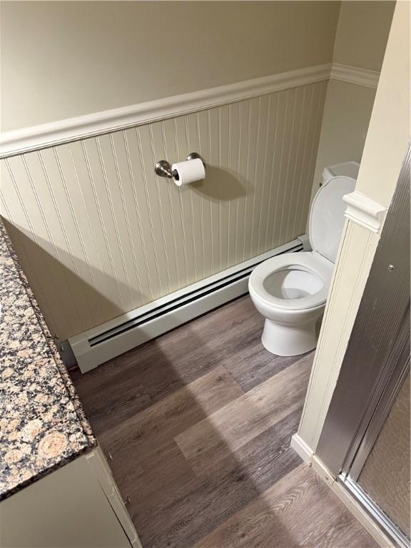 446 Angell Rd, North Providence, RI 02904 - bathroom featuring toilet, wood finished floors, a baseboard radiator, a wainscoted wall, and vanity