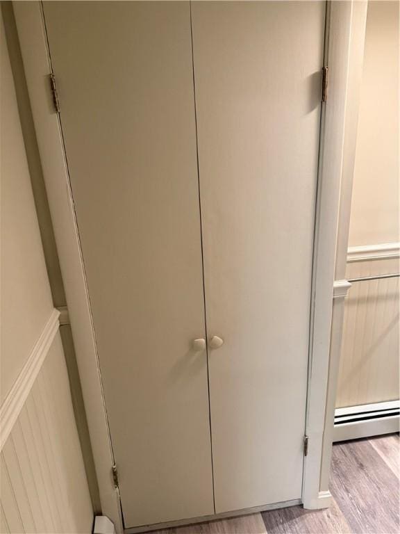 446 Angell Rd, North Providence, RI 02904 - detailed view of wood finished floors, baseboard heating, and a decorative wall