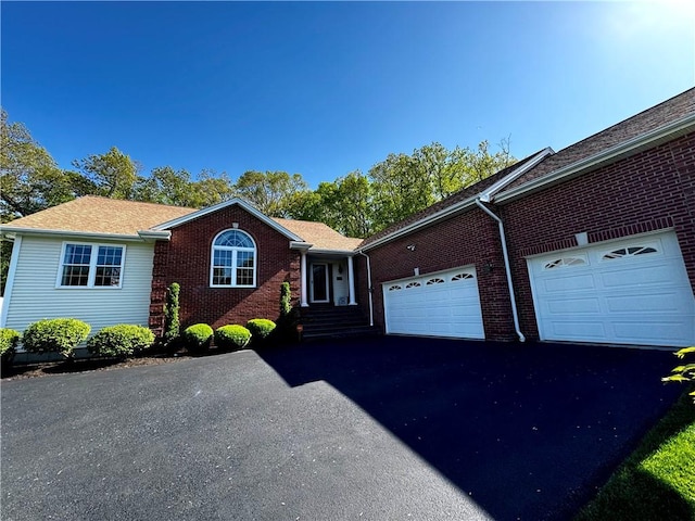 ranch-style house with an attached garage, driveway, and brick siding
