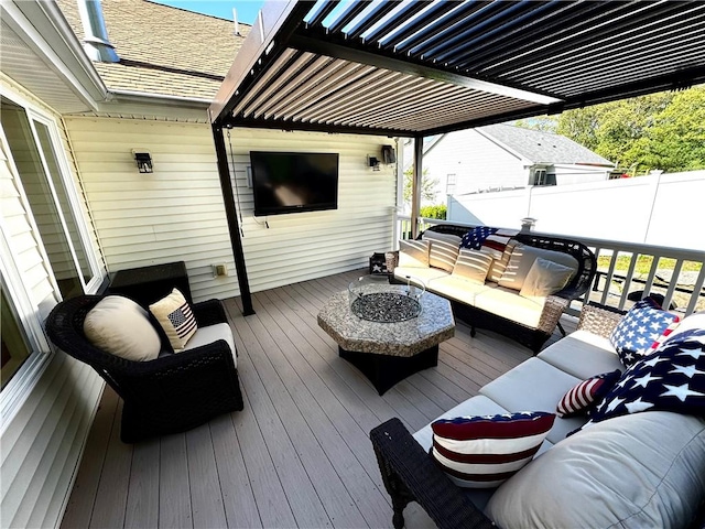 wooden deck with an outdoor hangout area, fence, and a pergola