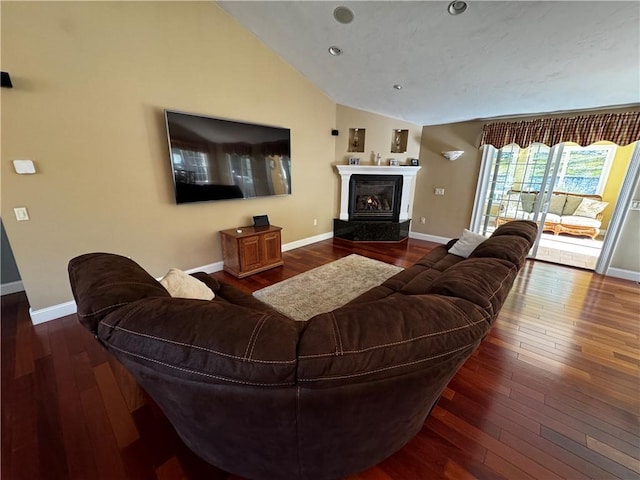 living area featuring vaulted ceiling, baseboards, wood-type flooring, a high end fireplace, and recessed lighting