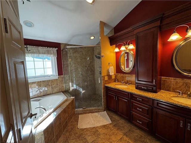 full bath featuring lofted ceiling, a shower stall, a bath, double vanity, and tile walls