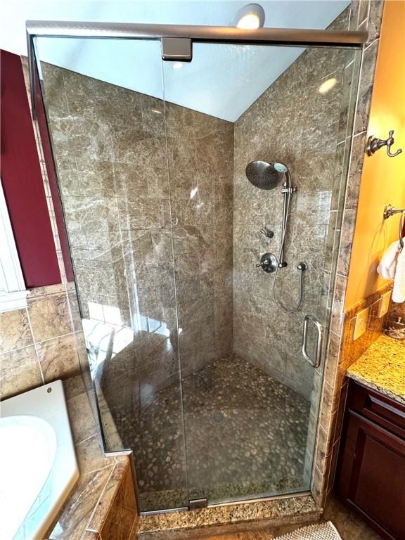 bathroom with a stall shower and a bath