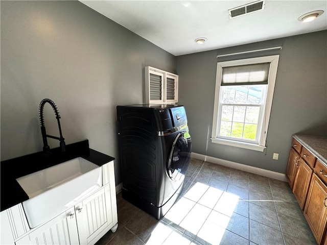 clothes washing area with cabinet space, baseboards, and tile patterned flooring