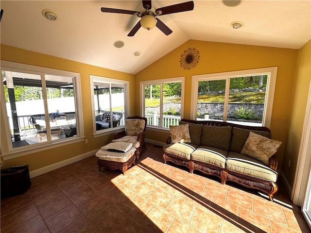 sunroom with lofted ceiling, baseboards, and tile patterned flooring
