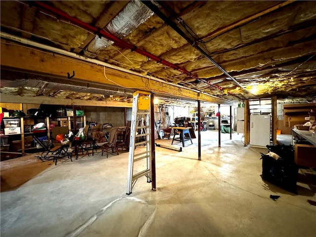 unfinished basement with fridge