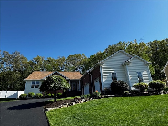 view of front of house with asphalt driveway and a garage