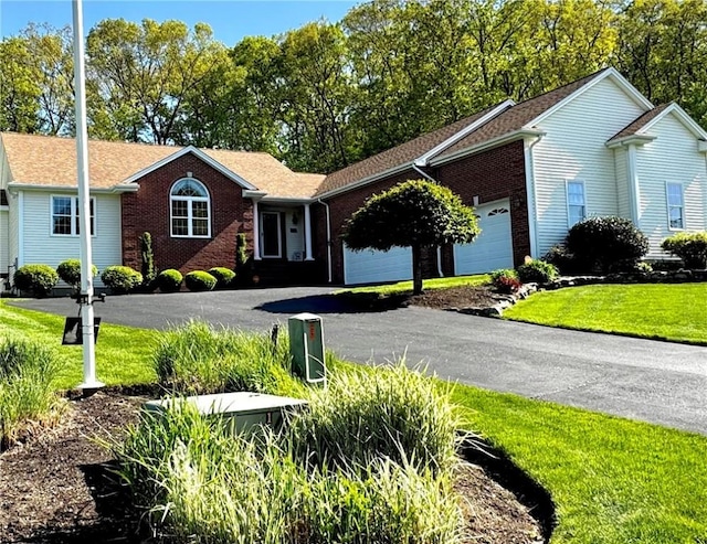 ranch-style home featuring an attached garage, brick siding, driveway, and a front lawn