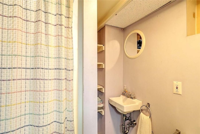 full bath with a shower with shower curtain and a sink