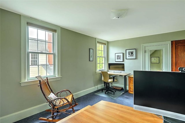 office space with plenty of natural light, baseboards, and dark carpet