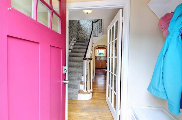 entrance foyer featuring wood finished floors, stairs, and french doors