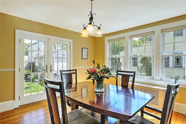 dining room with light wood-style flooring, a chandelier, and french doors