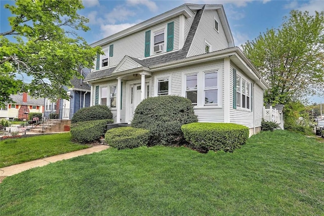 colonial inspired home featuring a front yard and cooling unit