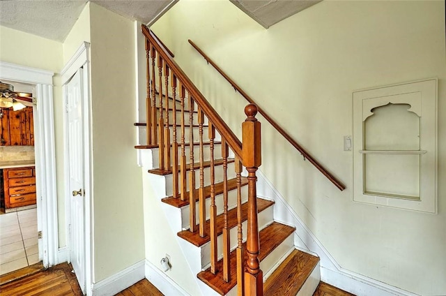 stairway featuring wood finished floors and baseboards