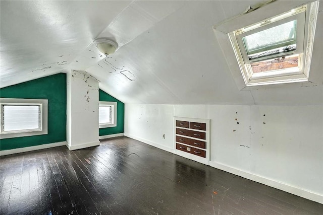 additional living space featuring baseboards, hardwood / wood-style flooring, and lofted ceiling