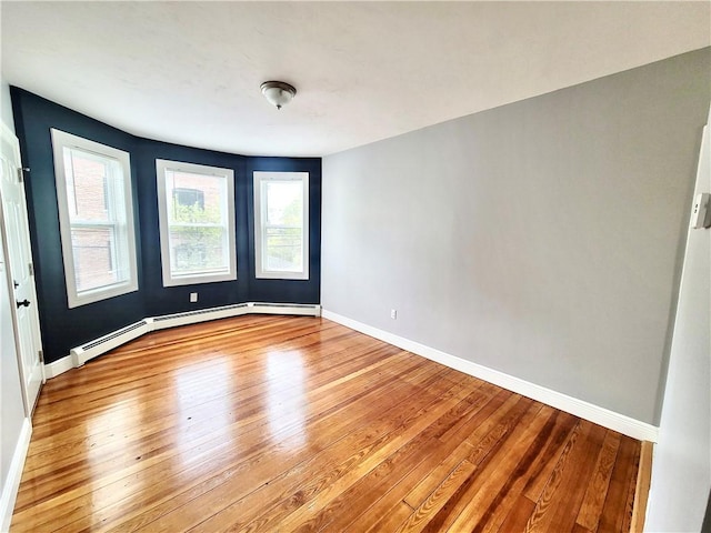 spare room with hardwood / wood-style floors and baseboards