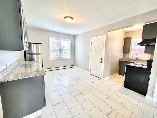 kitchen with freestanding refrigerator, baseboard heating, light marble finish flooring, electric stove, and under cabinet range hood