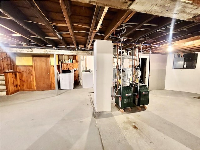 unfinished below grade area featuring electric panel and washing machine and clothes dryer
