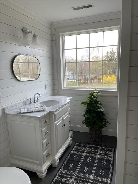 387 Camp Westwood Rd, Coventry, RI 02827 - half bath with wooden walls, vanity, ornamental molding, and toilet