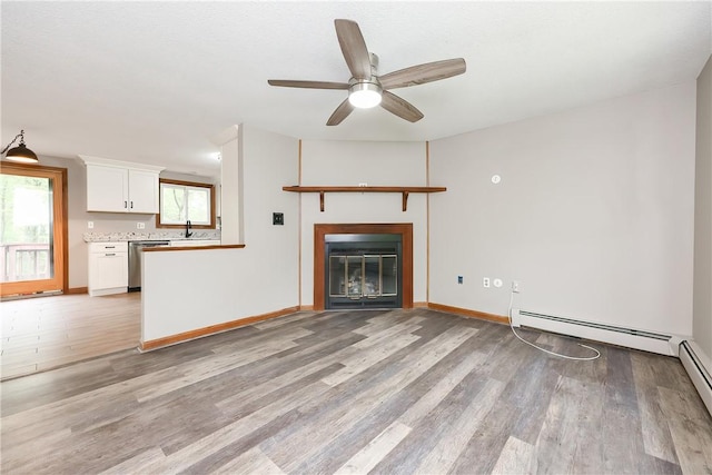 274 Courthouse Ln, Burrillville, RI 02859 - unfurnished living room featuring light wood-style flooring, ceiling fan, a baseboard heating unit, baseboards, and a glass covered fireplace