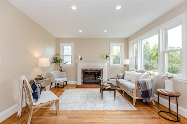 living room with baseboards, a fireplace, light wood-style flooring, and recessed lighting