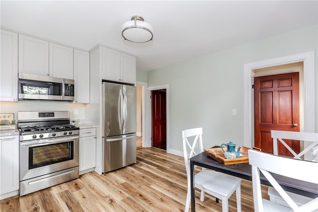 kitchen featuring stainless steel appliances, white cabinets, and light wood-type flooring