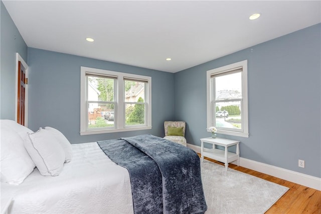 bedroom featuring baseboards, wood finished floors, and recessed lighting