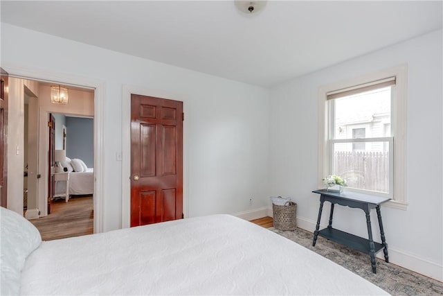 bedroom with baseboards and wood finished floors