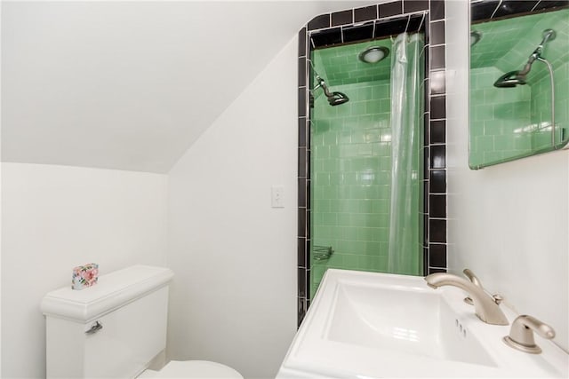 bathroom with vaulted ceiling, a sink, toilet, and tiled shower