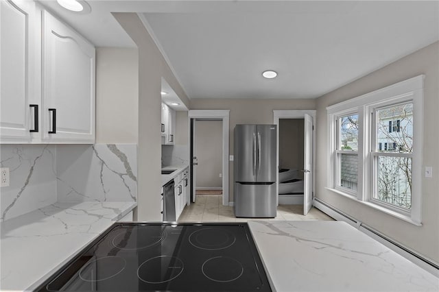 9 Lookout Ave, North Providence, RI 02911 - kitchen featuring freestanding refrigerator, white cabinetry, a baseboard heating unit, light stone counters, and backsplash