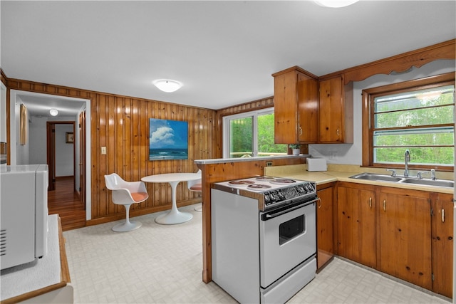 11 Cedar Ave, Middletown, RI 02842 - kitchen featuring white electric range oven, a sink, light countertops, light flooring, and brown cabinets