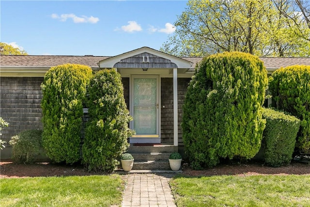 11 Cedar Ave, Middletown, RI 02842 - view of exterior entry with a lawn and a shingled roof
