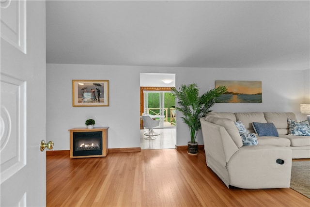 11 Cedar Ave, Middletown, RI 02842 - living area with wood finished floors, a lit fireplace, and baseboards
