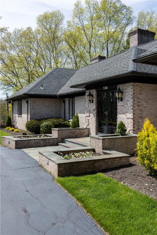 136 White Birch Cir, Scituate, RI 02831 - view of front facade featuring brick siding, roof with shingles, a chimney, and french doors
