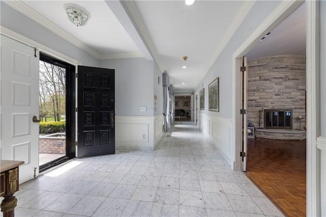 136 White Birch Cir, Scituate, RI 02831 - foyer entrance with a fireplace, wainscoting, a decorative wall, and crown molding