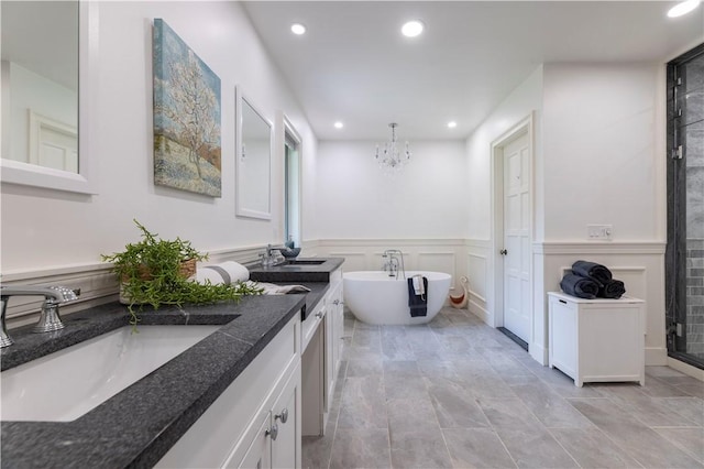 136 White Birch Cir, Scituate, RI 02831 - bathroom featuring recessed lighting, a chandelier, a freestanding bath, double vanity, and a wainscoted wall