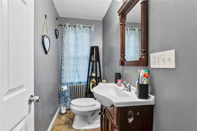 24 Seventh St, East Providence, RI 02914 - bathroom with baseboards, radiator heating unit, vanity, toilet, and tile patterned floors